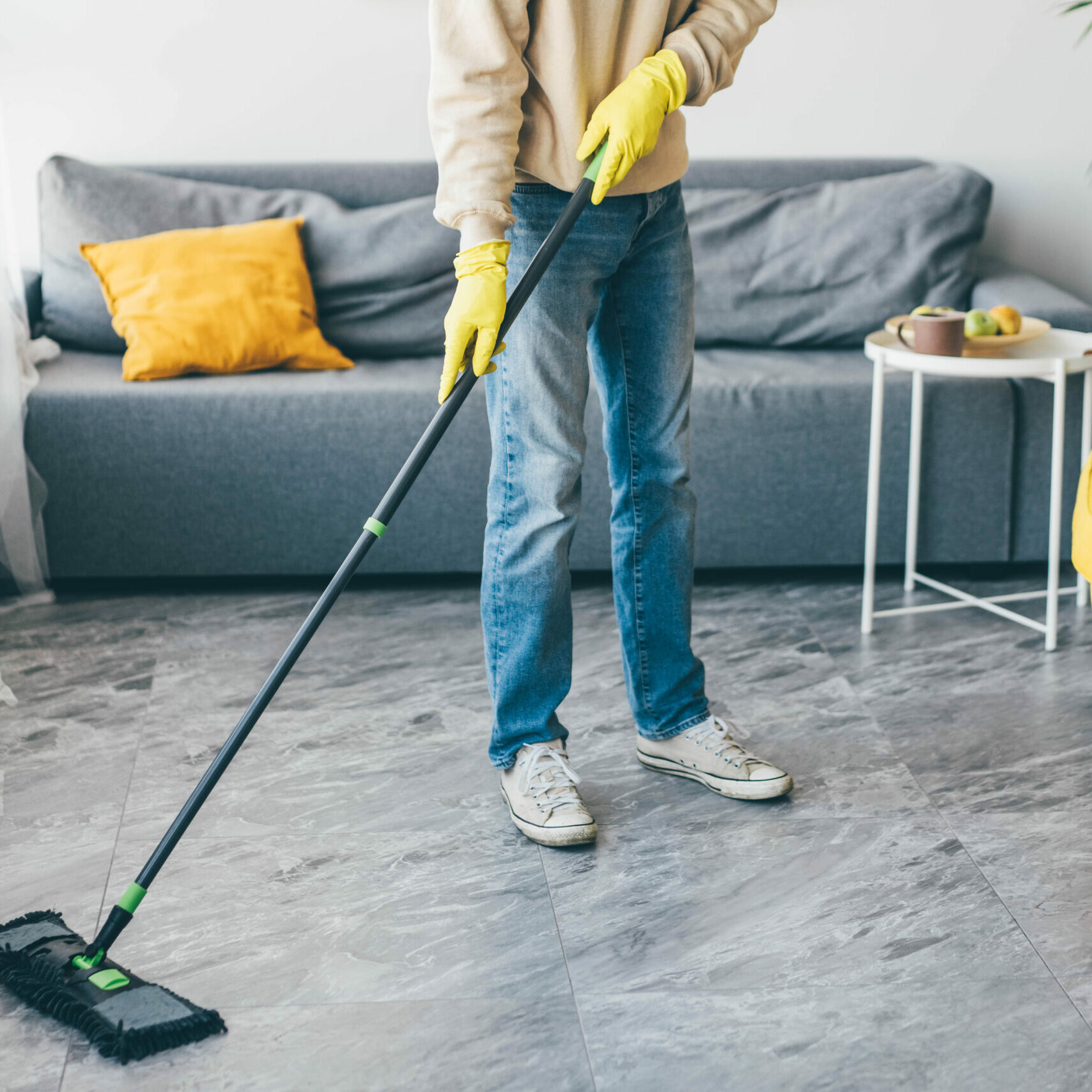 Man washes the floors with a mop in room.
